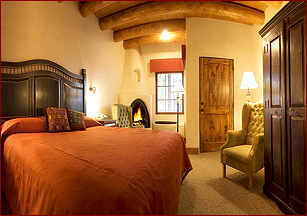 This beautifully appointed guest room at the Taos Inn features viga ceilings and a kiva fireplace.